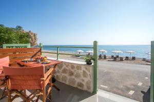 阿彻奇洛斯EGLI LUXURY APARTMENTS的一个带桌椅和海滩的阳台