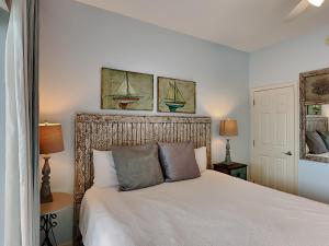 罗斯玛丽海滩Inn at Seacrest #206的卧室配有一张白色床,墙上挂有两幅画作