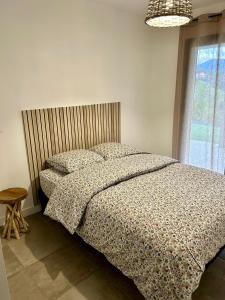 BastelicacciaBas de villa avec jardin idéalement situé entre Ajaccio et Porticcio的卧室配有带枕头的床铺和窗户。