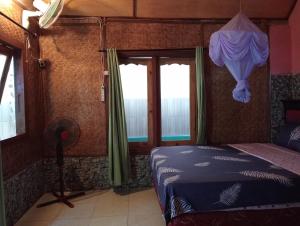 瑟克通Pelangi Homestay Bungalow Gili gede的一间卧室设有一张床和一个窗口