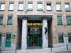 布鲁塞尔B&B HOTEL Brussels Centre Louise的一座大型砖砌建筑,上面有 ⁇ 巴酒店标志