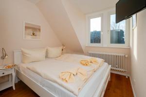提努姆Ferienhaus Sprotte的带2扇窗户的客房内的一张白色床