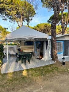 卡瓦利诺Caravan Cavallino - Valentini in Campeggio Union Lido的一个带桌子和帐篷的庭院