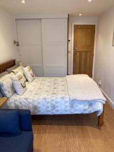 格拉辛顿Hardy Croft Hideaway的一间卧室配有一张大床和一张蓝色的沙发