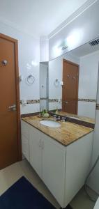 瓜鲁雅Flat Pitangueira com Piscina-Capitânia Varan的一间带水槽和大镜子的浴室