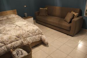 卡斯泰尔梅扎诺B&B Sud e Magia的一间卧室配有一张床和一张沙发