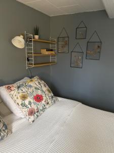 MjöhultTrennegården B&B的卧室配有一张带花枕的墙壁床