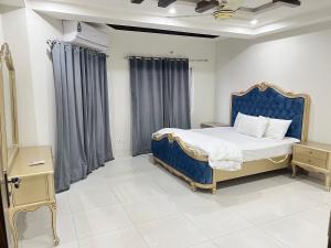 伊斯兰堡LUXURY HOTEL E11的一间卧室配有一张蓝色床头板的床