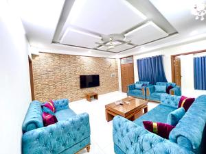 伊斯兰堡LUXURY HOTEL E11的客厅配有蓝色的沙发和电视