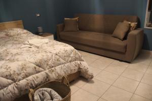 卡斯泰尔梅扎诺B&B Sud e Magia的一间卧室配有一张床和一张沙发