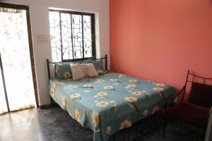阿姆波尔Dreamcatcher House & Hostel at Arambol Beach的一间卧室配有一张带蓝色棉被的床