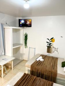 索雷Pousada Marajó For You的一间设有床铺和墙上电视的客房