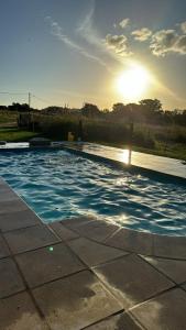 坦迪尔Casa quinta Don bosco的游泳池,享有阳光背景