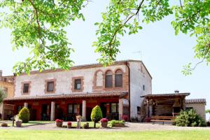 Serra de DaróCan Pujol - Turismo Rural的一座古老的建筑,前面设有长凳