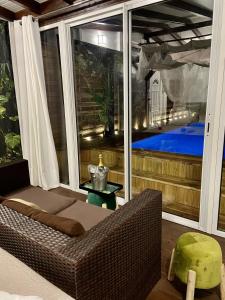 圣吕斯Eden Paradise Ecolodge & Spa的带沙发的客厅,享有游泳池的景色