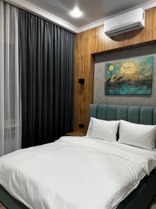 塔尔迪库尔干Sunrise Hotel的一间卧室配有一张白色大床和蓝色床头板