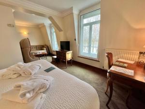 日安Logis Hôtel Le Rivage的一间卧室配有一张床、一张书桌和一个窗户。