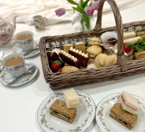 布罗肯赫斯特茅草屋酒店 的一张桌子,上面放着三明治盘和一篮茶