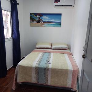 格兰德岛Casa de playa的小卧室配有一张带彩色毯子的床