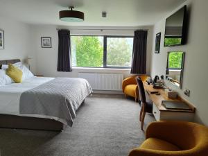 布雷肯Camden Lodge B&B and Cottage Brecon的一间卧室配有一张床、一张桌子和两把椅子