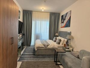 Al QurayyahBeautiful Cozy Studio (Masdar City)的一间卧室配有一张床和一张沙发