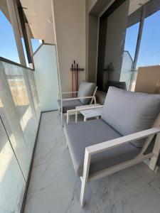Al QurayyahBeautiful Cozy Studio (Masdar City)的阳台配有两把椅子和窗户。