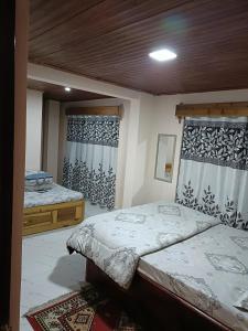 大吉岭PEARL HOMESTAY DARJEELING的一间卧室设有两张床和两个窗户。
