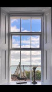 DundrumTonn Ruray Sea View Luxury 2 Bed Apartment的窗户,有帆船在房间里