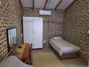 雾观Numbi Hills Self-Catering的一间卧室设有一张床和砖墙