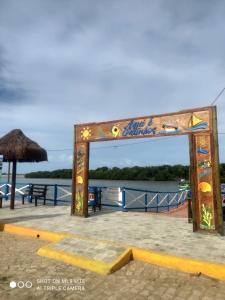 加利纽斯Pousada Galinhos的码头上的一个标志,水背景