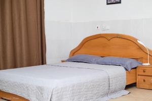库马西Luxury Apartments的卧室内的一张带木制床头板的床
