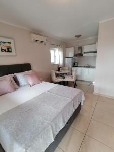 罗佐瓦克Apartmani Marijana的卧室配有带粉红色枕头的大型白色床
