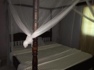 蒙巴萨Tropical paradise的天蓬床,上面有白色的天蓬窗帘