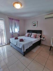 罗佐瓦克Apartmani Marijana的卧室配有一张带粉红色枕头的大床