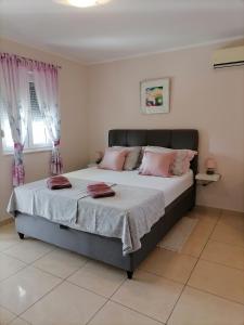 罗佐瓦克Apartmani Marijana的一间卧室配有带粉红色枕头的床。