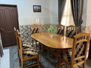 库马西Luxury Spacious Apartment的一间带木桌和椅子的用餐室