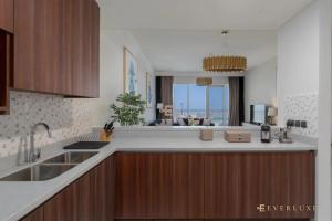 迪拜Everluxe Palm Views 3 Bedroom的厨房配有水槽和台面