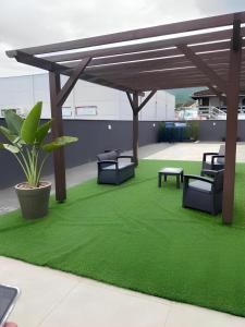 波梅罗迪Flat Home Business Centro de Pomerode的一个带绿草的庭院和木制凉亭