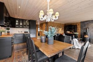 高尔Cozy cabin with sauna, ski tracks and golf outside的厨房以及带木桌的用餐室。