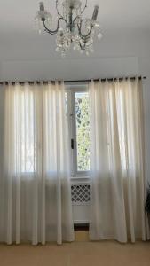 突尼斯Nomads Hostel Tunisia的窗户配有白色窗帘和吊灯