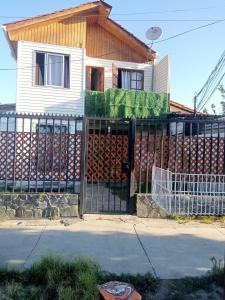 圣地亚哥Habitaciones Pabla的房屋前的围栏,有很多木头