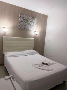 卡塔赫纳HOTEL NUEVO ARIZONA的一张白色的床,上面有盘子