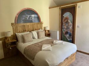 马特洛克Explorers Retreat Matlock Bath的卧室配有一张大床,墙上挂有绘画作品