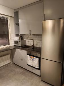玛丽港Lägenhet på markplan的厨房配有不锈钢冰箱和微波炉。