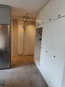 玛丽港Lägenhet på markplan的空厨房配有白色橱柜和冰箱
