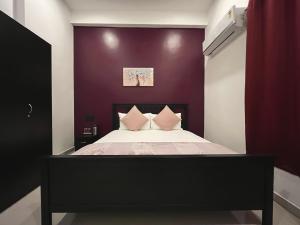 阿里巴格KIANA STAYS的一间卧室配有一张紫色墙壁的床