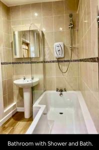 布雷肯Kookaburra lodge的带淋浴、盥洗盆和浴缸的浴室