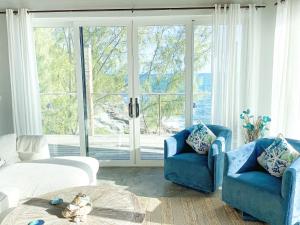 Hatchet Bay Limited SettlementOcean Shire home的客厅设有2把蓝色椅子和大窗户