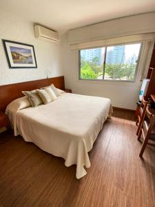 埃斯特角城阿贾克斯酒店的卧室设有一张白色大床和一扇窗户。