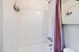 纽约Inspiring Urban Life, Times square Apartments的浴室配有白色浴缸和淋浴。